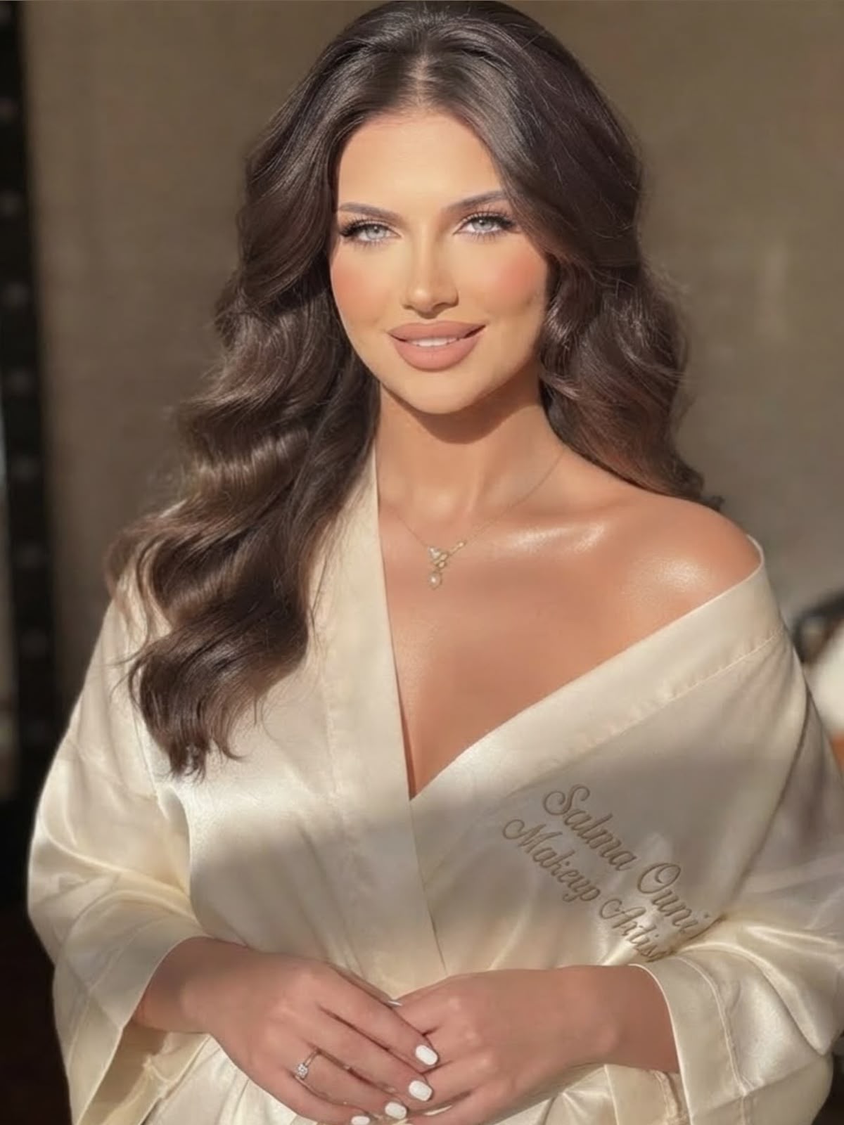 Maquillage mariée sur peau mate, regard fondu et robe en dentelle